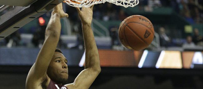 Virginia Tech’s Trevor Thompson (32) dunks as Miami’s Raphael Akpejiori watches in this photo from March 12, in Greensboro, N.C. Thompson has been granted his release and has been contacted by Kansas University coaches, according to a published report.