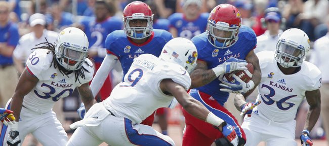 Blue Team running back Darrian Miller cuts through White Team defenders Fish Smithson (9), Tevin Shaw (30) and Chevrick Graham (36) during the second half of the Kansas Spring Game on Saturday, April 12, 2014 at Memorial Stadium. Nick Krug/Journal-World Photo