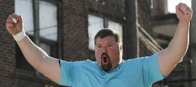 Christian Cantwell celebrates a throw to move into first place during the fourth-annual Lawrence Downtown Shot Put event Friday. Cantwell won the event.
