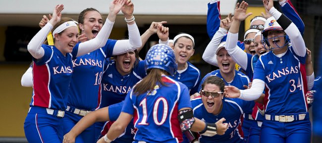 Members of the Kansas University softball team celebrate at the plate after Taylor Hatfield (10) hit a two-run home run in the first inning of Friday's NCAA regional softball game against Nebraska on Friday, May 16, 2014, in Columbia, Mo.