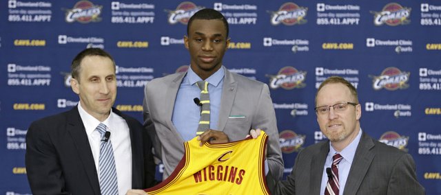 Cleveland Cavaliers head coach David Blatt, left to right, Andrew Wiggins and general manager David Griffin hold up Wiggins jersey during a new conference Friday, June 27, 2014, in Independence, Ohio.