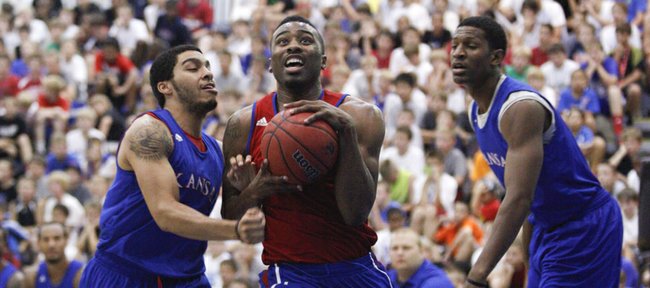 Former guard Keith Langford heads to the bucket between Niko Roberts, left, and Andrew White during a scrimmage on Wednesday, June 20, 2012 at the Horejsi Center. Nick Krug/Journal-World Photo