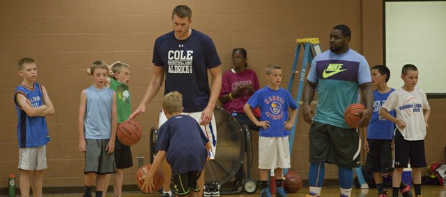 Former Kansas basketball player and current NBA player Cole Aldrich, left, and former KU player Sherron Collins work with campers at Aldrich's basketball camp Monday, July 7, 2014, at Robinson Gym at KU.