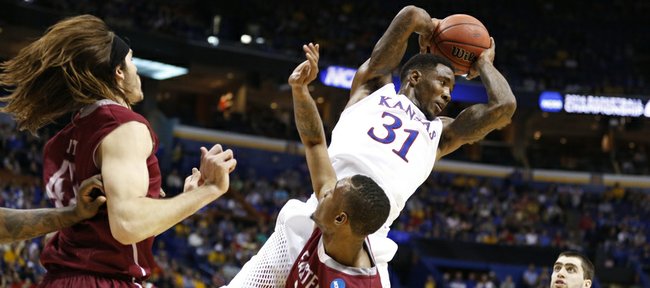Kansas forward Jamari Traylor grabs an offensive rebound over Eastern Kentucky guard Orlando Williams during the second half on Friday, March 21, 2014 at Scottrade Center in St. Louis.