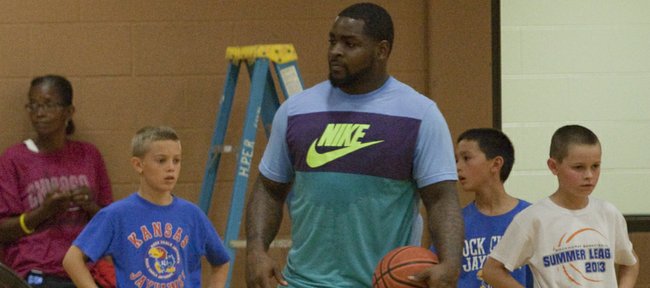 Former Kansas basketball player and current NBA player Cole Aldrich, left, and former KU player Sherron Collins work with campers at Aldrich's basketball camp Monday, July 7, 2014, at Robinson Gym at KU.