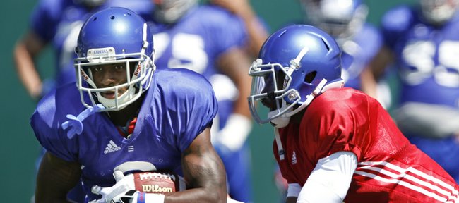 Kansas' Tony Pierson takes a handoff from quarterback Montell Cozart during practice on Monday, August 11, 2014.