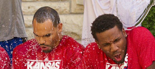 Kansas men's basketball players Perry Ellis, left, and Wayne Selden react as head coach Bill Self helps pour buckets of ice water onto them while they participate in the ALS Ice Bucket Challenge, Sunday afternoon outside of the Wagnon Student Athlete Center.