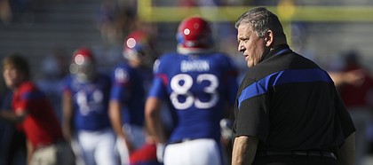 Kansas head coach Charlie Weis watches over warmups prior to the Jayhawks' season opener against Southeast Missouri State on Saturday, Sept. 6, 2014 at Memorial Stadium.