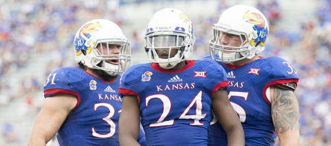 Kansas' Ben Heeney, left, JaCorey Shepherd (24) and T.J. Semke celebrate Shepherd's broke up pass during  the second half of their  game against Central Michigan Saturday afternoon at Memorial Stadium.