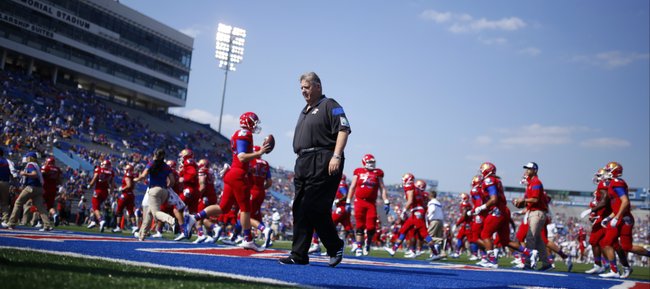 Kansas head coach Charlie Weis walks off the field as the Jayhawks warm up prior to kickoff against Texas on Saturday, Sept. 27, 2014 at Memorial Stadium.