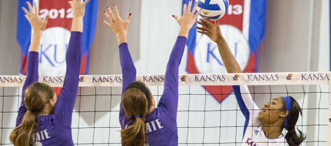 Kansas junior outside hitter Tiana Dockery (7) looks to hit past Kansas State's Natali Jones (12) and Katie Brand (6) during their volleyball match Wednesday evening at the Horejsi Center. 