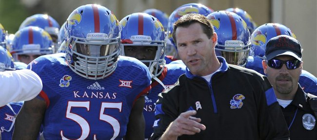 Kansas interim head coach Clint Bowen talks to senior Michael Reynolds just before the Jayhawks take the field Saturday afternoon. Kansas dropped the game 27-20 to Oklahoma State.