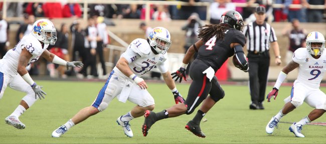 Texas Tech receiver Bradley Marquez makes a move against Kansas defenders Cassius Sendish (33), Ben Heeney (31), and Fish Smithson (9) during the second quarter on Saturday, Oct. 18, 2014 at Jones AT&T Stadium in Lubbock, Texas.