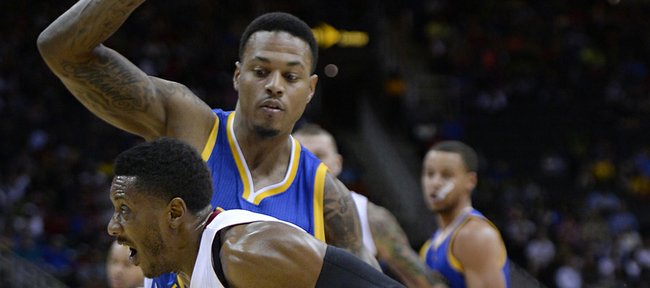 Miami’s Mario Chalmers, front, drives against Golden State’s Brandon Rush in an NBA exhibition on Friday in Kansas City, Missouri.