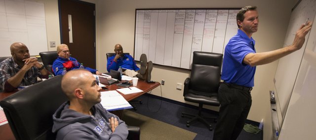 Kansas interim head football coach Clint Bowen works through a defensive plan for Baylor with coaches Scott Vestal, front, Ty Greenwood, Dave Campo and Buddy Wyatt on Wednesday, Oct. 22, 2014.