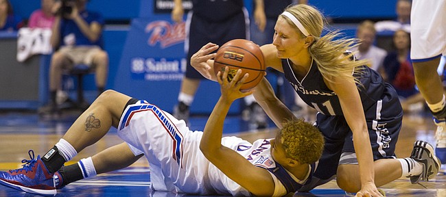 Washburn senior guard Allyssa Nikkel (11) forces a tie up at mid court with Kansas senior guard Asia Boyd during their exhibition basketball game Sunday afternoon at Allen Fieldhouse. The Jayhawks defeated the Ichabods, 78-58, and will open the season for real next Sunday against South Dakota. Tip off time is set for 2 p.m. at Allen Fieldhouse. 