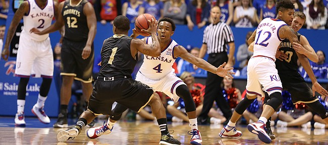 Kansas guard Devonte Graham reaches to defend against a pass from Emporia State guard Perryonte Smith during the first half on Tuesday, Nov. 11, 2014.