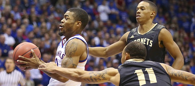 Kansas guard Frank Mason gets to the bucket past Emporia State guards Terrence Moore (11) and Tyler Jordan during the first half on Tuesday, Nov. 11, 2014.