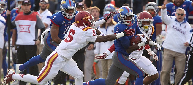 Kansas running back Tony Pierson gets up the field past Iowa State defenders Kamari Cotton-Moya (5) and Nigel Tribune, back, during the first quarter on Saturday, Nov. 8, 2014.