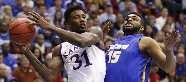 Kansas forward Jamari Traylor looks to sling a pass across the court as he is defended by UC Santa Barbara forward Alan Williams during the first half on Friday, Nov. 14, 2014 at Allen Fieldhouse.