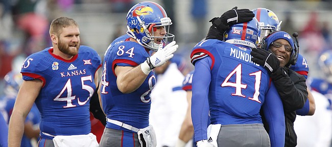 Kansas tight end Jimmay Mundine is congratulated by running backs coach Reggie Mitchell and teammates Ben Johnson (84) and Ed Fink (45) after his touchdown against TCU during the second quarter on Saturday, Nov. 15, 2014 at Memorial Stadium.