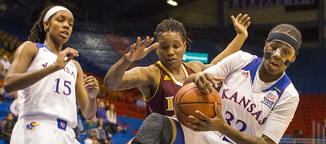 Kansas sophomore guard Keyla Morgan (32) rips a rebound away from Iona forward Joy Adams during first half action in their game Wednesday evening at Allen Fieldhouse. 