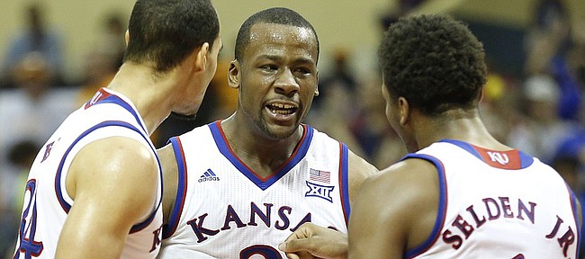Kansas players Perry Ellis, left, Cliff Alexander and Wayne Selden celebrate a bucket by Alexander late during the second half on Friday, Nov. 28, 2014 at the HP Field House in Kissimmee, Florida.