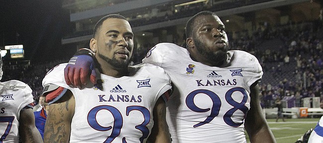 Kansas defensive lineman Ben Goodman (93) and Keon Stowers (98) walk off the field at the end of the Jayhawks 51-13 loss to the Kansas State Wildcats Saturday in Manhattan. .