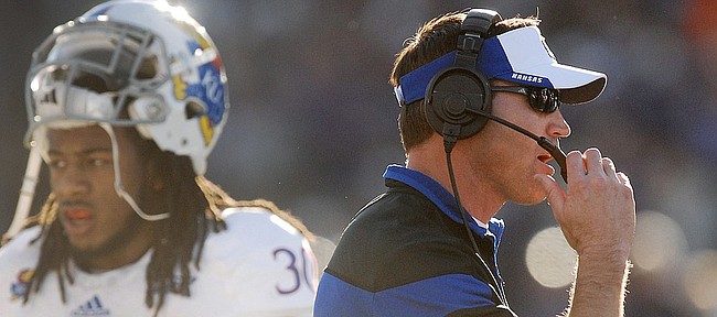 Kansas Jayhawks football coach Clint Bowen, right, directs the Jayhawks in their game against the Kansas State Wildcats Saturday in Manhattan. At left is KU sophomore, Tevin Shaw, (30).