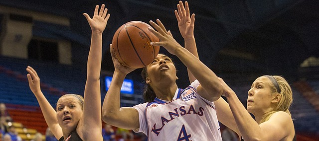 Kansas sophomore forward Jada Brown (4) looks for her shot after splitting Incarnate Word defenders Aelina Merritt (12) and Quincy Baker (24) during the first half of their game Thursday evening at Allen Fieldhouse.