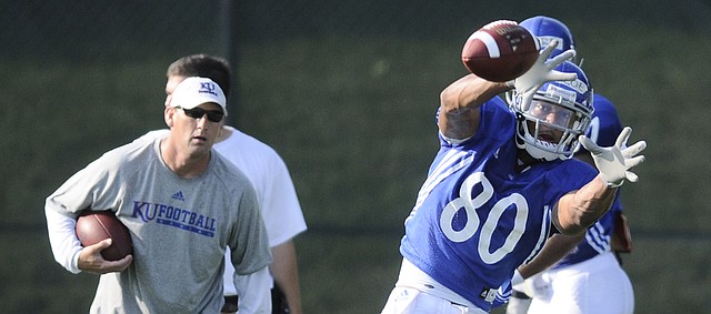 Under the watchful eyes of then-Kansas University receivers coach David Beaty, left, Dezmon Briscoe pulls in a pass during practice in this photo from Aug. 11, 2009. Briscoe is among those glad Beaty is returning to KU — as head coach.