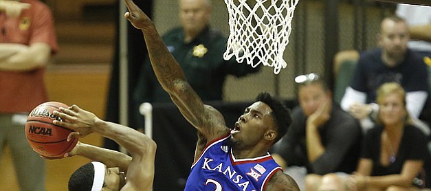 Kansas forward Jamari Traylor (31) defends against a shot from Rhode Island guard E.C. Matthews (0) during the first half on Thursday, Nov. 27, 2014 at the HP Field House in Kissimmee, Florida.
