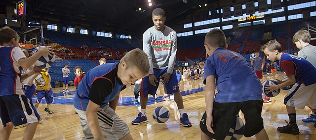 Young basketball players work on dribbling drills with Frank Mason III during the KU men's basketball Holiday Clinic Sunday, Dec. 28, 2014 at Allen Fieldhouse.
