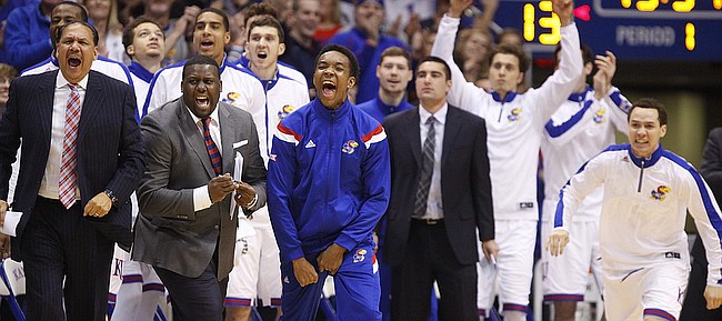 Injured Kansas guard Devonte Graham, center, and the rest of the bench react to a steal and a bucket by point guard Frank Mason during the first half against UNLV on Sunday, Jan. 4, 2015 at Allen Fieldhouse. 