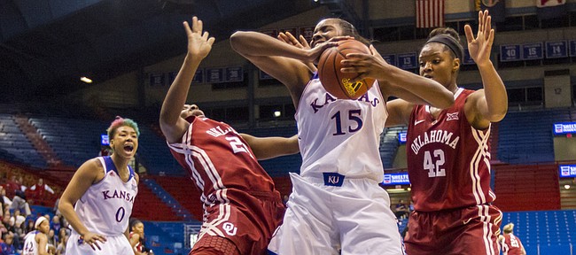 Kansas senior forward Chelsea Gardner (15) sends Oklahoma senior guard Sharane Campbell-Olds to the court with her elbow after clearing out a rebound during the first half of their game Wednesday evening at Allen Fieldhouse. The Jayhawks fell to the Sooners 69-57. Also pictured is junior forward Kaylon Williams (42) and senior guard Asia Boyd (0).