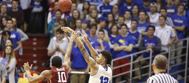Kansas guard Kelly Oubre Jr. (12) puts up a three from the corner against Oklahoma guard Jordan Woodard (10) during the second half on Monday, Jan. 19, 2015 at Allen Fieldhouse.