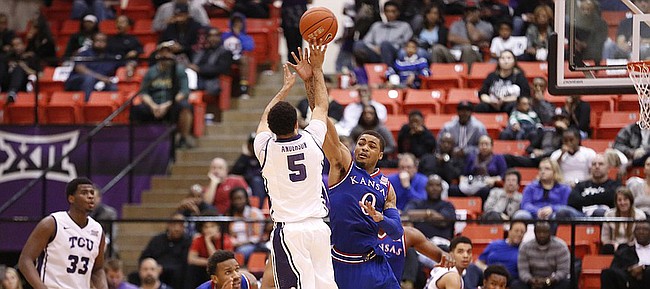 Kansas guard Frank Mason III (0) fouls TCU Horned Frogs guard Kyan Anderson (5) on a three-pointer with little time remaining during the second half at Wilkerson-Greines Activity Center on Wednesday, Jan. 28, 2015 in Fort Worth, Texas.