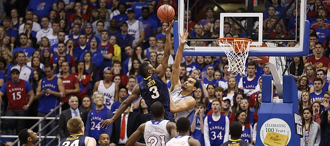Kansas forward Perry Ellis defends as West Virginia guard Juwan Staten puts up a shot during the first half on Saturday, Feb. 8, 2014 at Allen Fieldhouse.