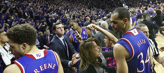 Kansas forward Perry Ellis and Kansas guard Brannen Greene try to move to the sidelines as Kansas State fans rush the court following the Jayhawks' 70-63 loss to the Wildcats, Monday, Feb. 23, 2015 at Bramlage Coliseum.