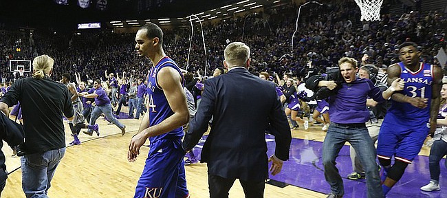 Kansas forward Perry Ellis moves to the sideline as fans rush the court following the Jayhawks' 70-63 loss to the Wildcats, Monday, Feb. 23, 2015 at Bramlage Coliseum. At right, a Kansas State fan bumps into Kansas forward Jamari Traylor.