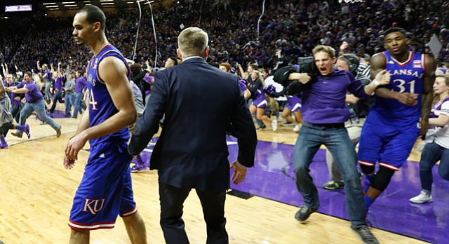 Kansas forward Perry Ellis moves to the sideline as fans rush the court following the Jayhawks' 70-63 loss to the Wildcats, Monday, Feb. 23, 2015 at Bramlage Coliseum. At right, a Kansas State fan bumps into Kansas forward Jamari Traylor.