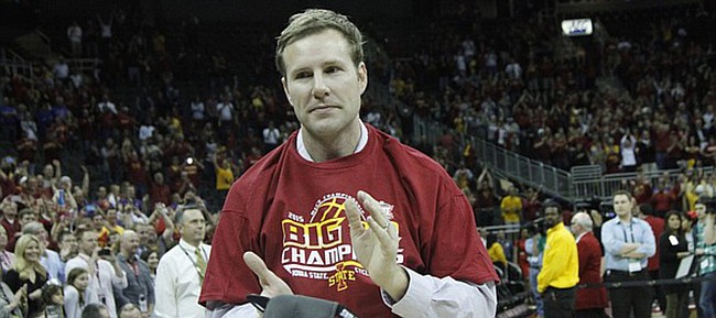 Iowa State coach Fred Hoiberg holds a championship hat and claps for his Cyclones after winning the Big 12  Tournament on Saturday, March 14, 2015. ISU beat Kansas 70-66 in Kansas City, Missouri.