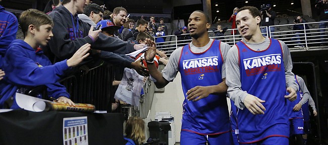 Kansas guards Wayne Selden Jr. and Evan Manning head to the court for a second-round practice session Friday 19, 2015.