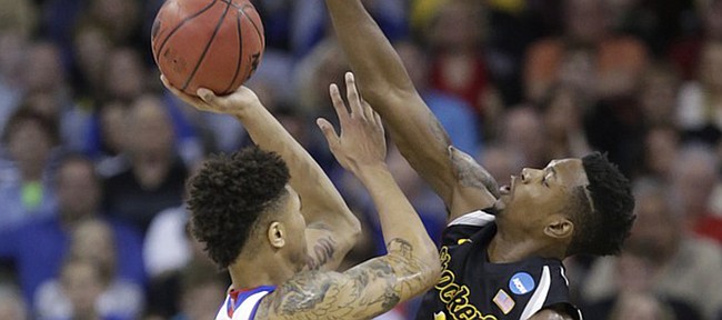 Kansas guard Kelly Oubre, Jr. (12) is defended by Wichita State forward Zach Brown (1) as he takes a shot in the Jayhawks' loss to Wichita State Sunday, March 22, 2015 at the CenturyLink Center, in Omaha, Neb.