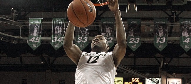 Charlotte's Mike Thorne Jr. (12) dunks over Miami's Omar Sherman (22) during the second half of an NCAA college basketball game in Charlotte, N.C., Tuesday, Nov. 25, 2014. Miami won 77-74. (AP Photo/Chuck Burton)

