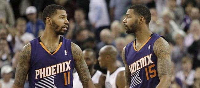 Phoenix Suns' Markieff Morris, left, shakes hands with his twin brother Marcus, as they walk off the court after the Suns 107-104 loss to the Sacramento King in a NBA basketball game in Sacramento, Calif., Tuesday, Nov. 19, 2013.(AP Photo/Rich Pedroncelli) 