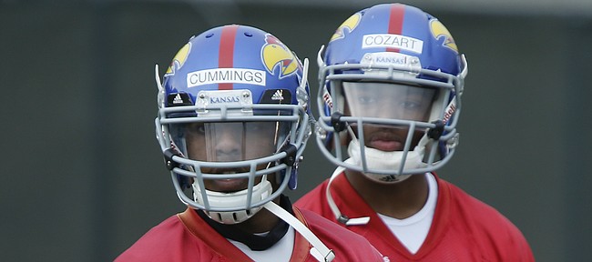 Kansas quarterbacks Michael Cummings and Montell Cozart listen as they receive direction from offensive coordinator Rob Likens during spring practice on Tuesday, March 24, 2015.