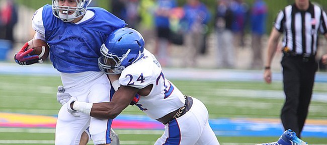 Blue Team running back Ryan Schadler is tacked by White Team safety Bazie Bates IV during the Spring Game on Saturday, April 25, 2015 at Memorial Stadium.