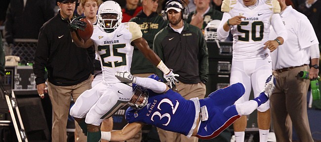 Kansas linebacker Schyler Miles is slung out of bounds while trying to bring down Baylor running back Lache Seastrunk during the first quarter on Saturday, Oct. 26, 2013.