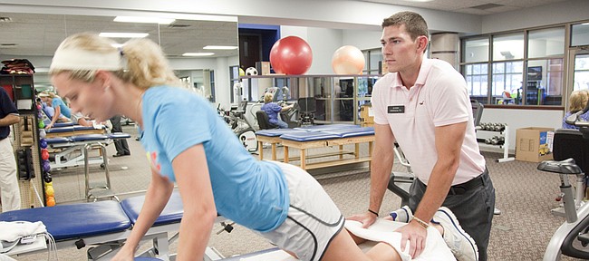 Kansas University guard Tyrel Reed works with Jenna Brantley, a Baker University senior guard who tore her ACL, 
in this file photo from 2010. Reed, who at the time was an intern at OrthoKansas, joined the Lawrence practice as a physical therapist on Monday, May 18, 2015.